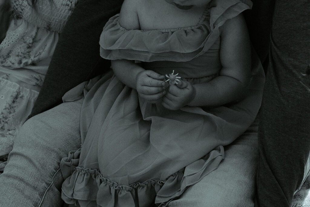 child holding flower in black and white